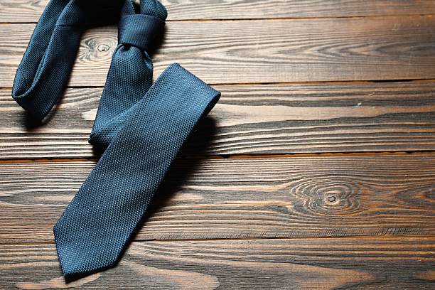 istock One blue necktie on wooden table, top view. Space for text 2248469256