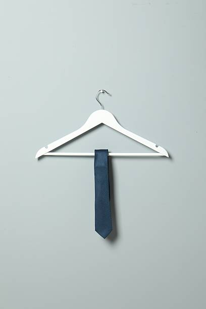 istock Hanger with blue necktie on light grey wall 2248469317