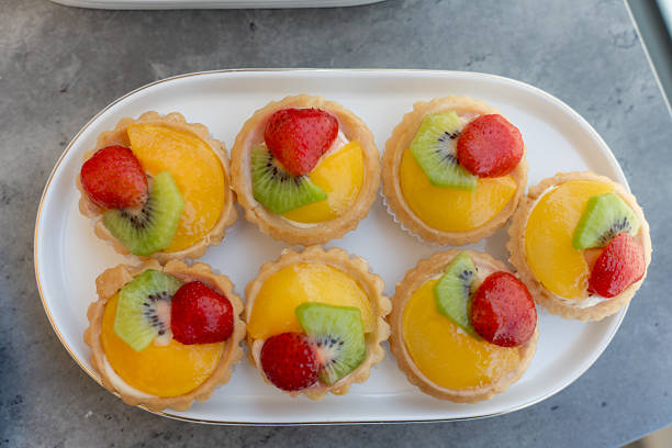 istock Colorful fruit tarts arranged neatly on a white platter for a delightful dessert experience 2248472400