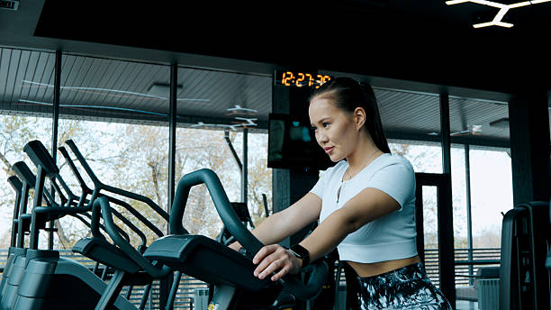 istock A woman is actively using an elliptical training machine in a gym setting 2248473898
