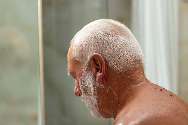 Mature man taking care of his face while shaving at home.
