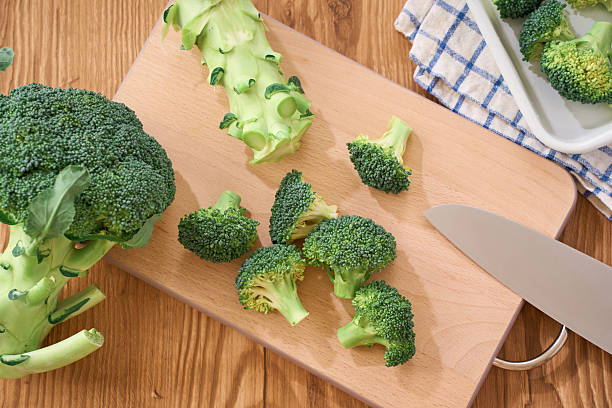 istock Fresh Broccoli Florets Being Prepared on Wooden Cutting Board 2248476730