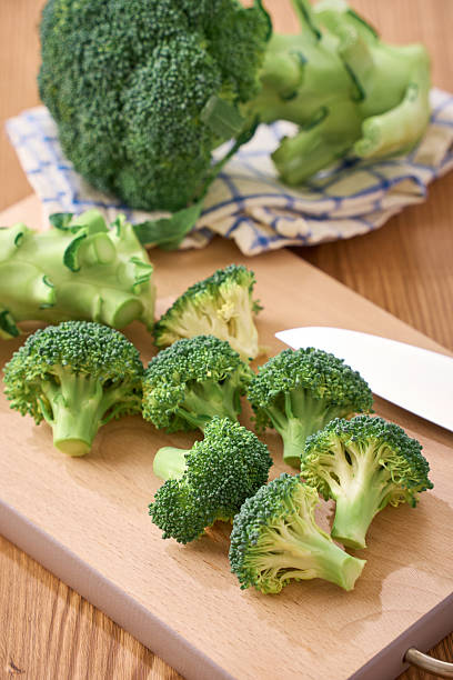 istock Fresh Broccoli Florets Being Prepared on Wooden Cutting Board 2248476764