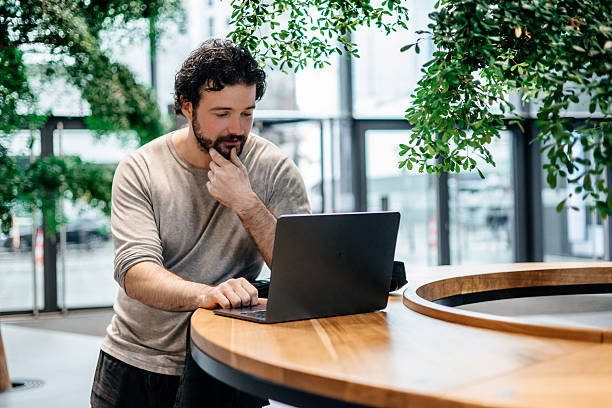 istock Male Freelancer Using Laptop in Bright Eco-Friendly Interior 2248476789