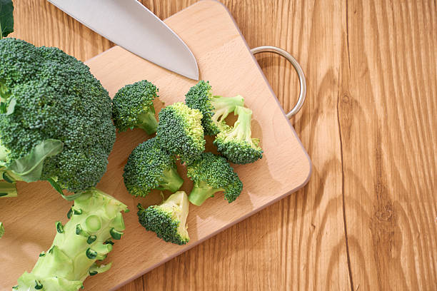 istock Fresh Broccoli Florets Being Prepared on Wooden Cutting Board 2248478384