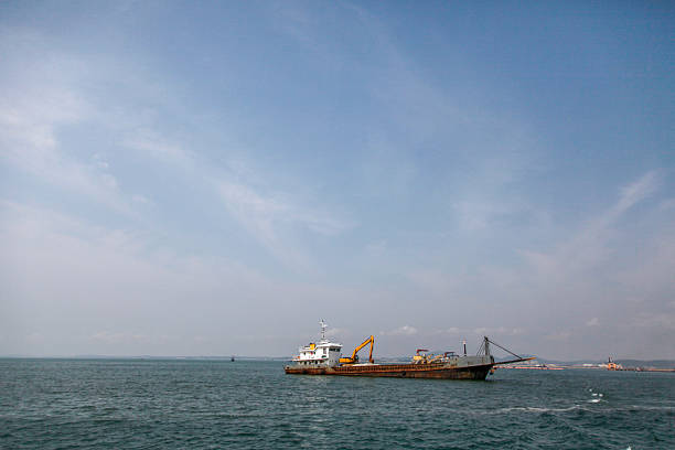 A ship is seen floating on the sea with a clear sky above, indicating maritime transportation and outdoor scene.