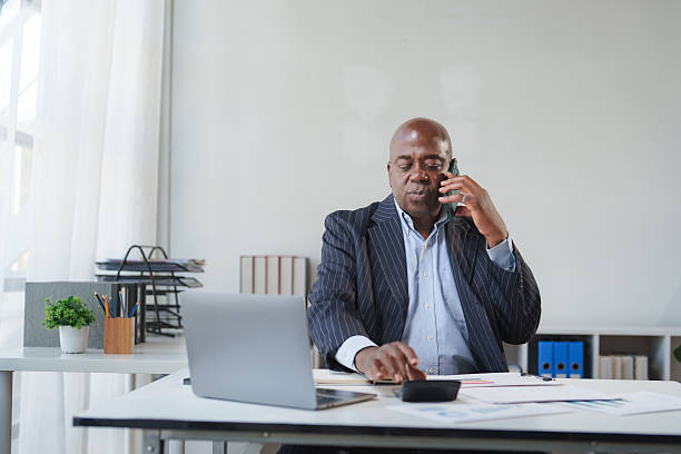 istock Mature businessman having phone conversation calculating finances 2248480209