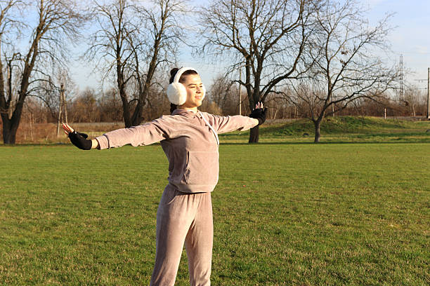Beautiful young woman doing exercises outdoors