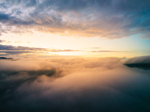 Fog and Clouds Over Mountain Landscape During Sunset – Drone View