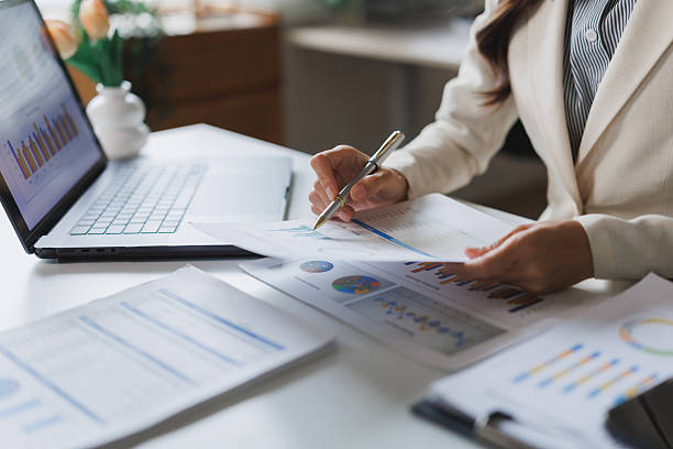 istock Businesswoman analyzing financial charts and data on desk with laptop 2248483021