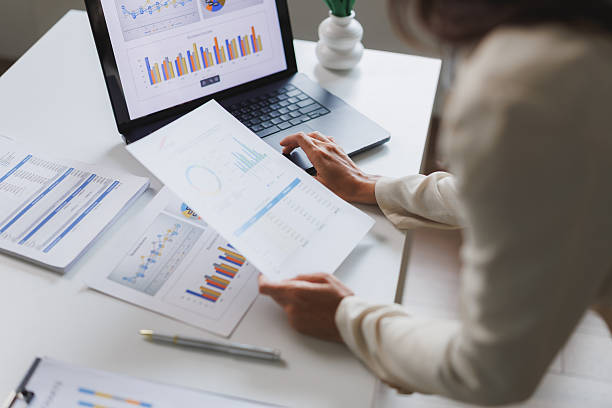 istock Businesswoman analyzing financial charts and data on laptop and documents 2248483046
