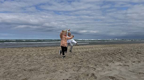 A vivid moment of children jumping high in the air on the beach, conveying intense joy, freedom, and spontaneous fun. Family activity themes.
