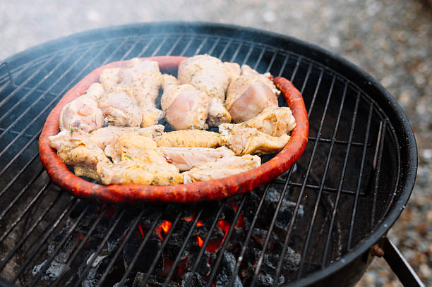 Sausages and chicken wings being grilled in a barbecue