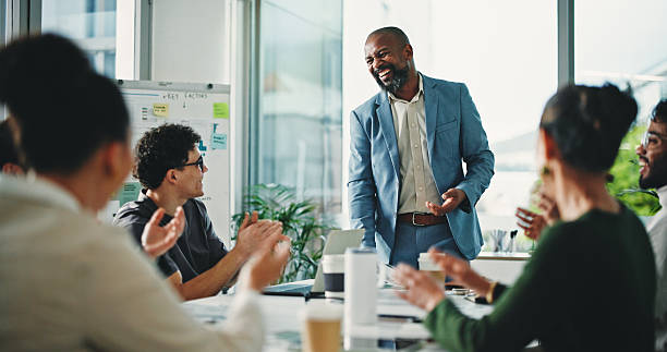istock Man, celebration and applause with office presentation, team and success with support at finance company. Person, speaker and paperwork with group, smile or achievement with goal at investment agency 2248494321