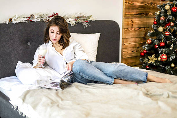 girl with a glass and a magazine on the bed