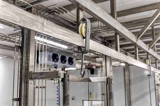 istock stainless steel overhead conveyor system with a hook and pulley, used in food processing facilities such as meat packing plants 2248498690