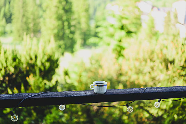 Coffee mug on a wooden balcony railing