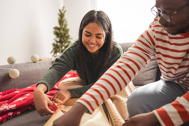 istock Couple wrapping christmas presents together during holidays 2248503464