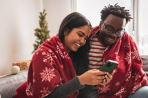 istock Diverse couple enjoying christmas holidays watching smartphone together 2248503517