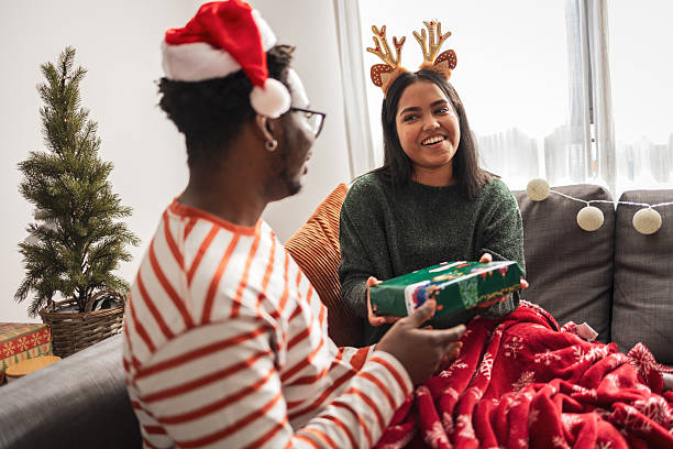 istock Diverse couple exchanging christmas gifts during holiday celebration 2248503523