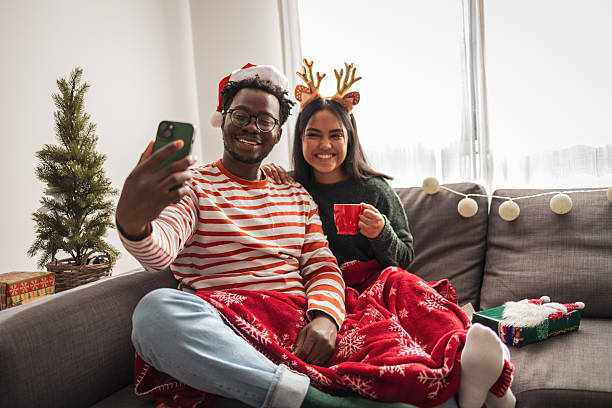 istock Diverse couple taking christmas selfie on cozy sofa 2248503537