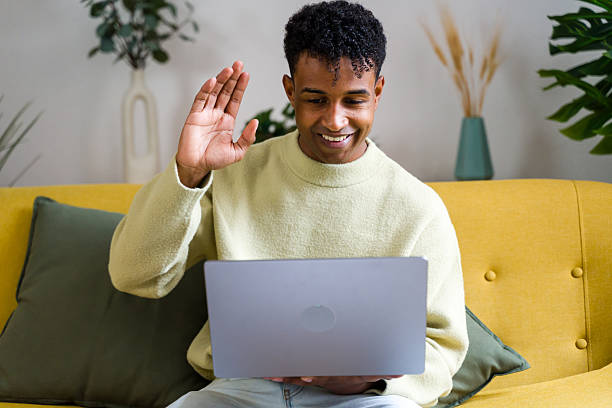 istock Young man waving during video call on laptop 2248507069