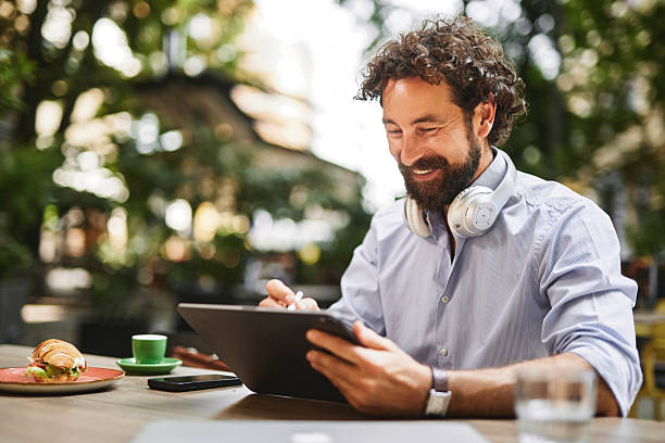istock Businessman working on tablet at outdoor cafe, enjoying a break 2248508474