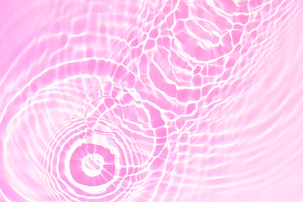 istock Pink water bubbles on the surface ripples. Defocus blurred transparent pink colored clear calm water surface texture with splash and bubbles. Water waves with shining pattern texture background 2248509899