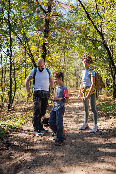 istock Boy with his parents on footpath in the woods on a sunny day 2248509934