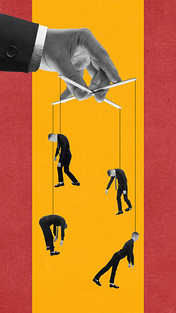 istock Modern composition of giant hand controlling human puppets on strings against yellow background 2248510038