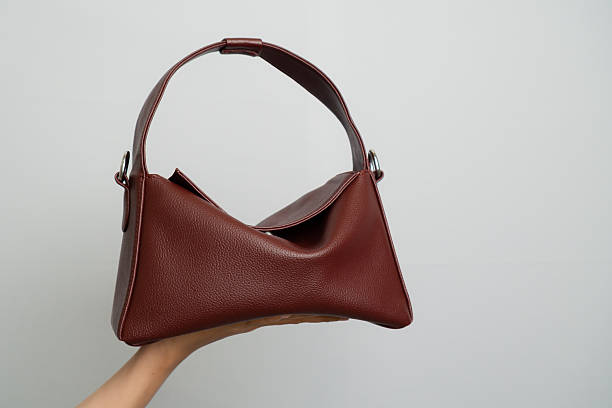 istock Dark red leather bag in woman's hand with grey l;atar bel;akang 2248513169