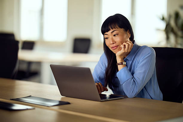 istock Asian Woman Working On Laptop In Modern Office Workspace, Focused And Thoughtful 2248517197