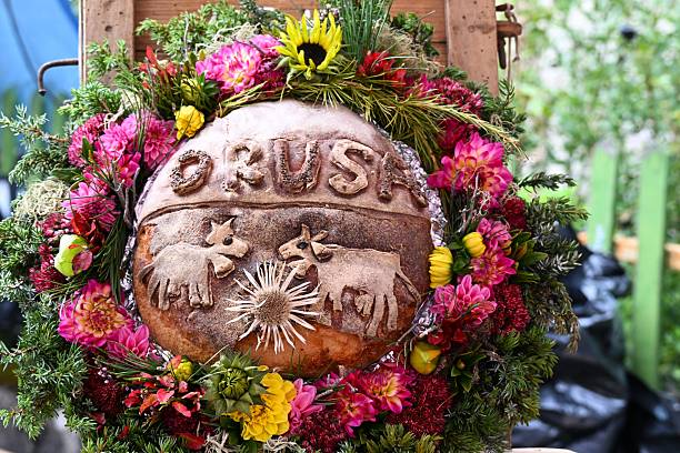Decorative bread with animal motifs surrounded by vibrant flowers and greenery, showcasing intricate craftsmanship.