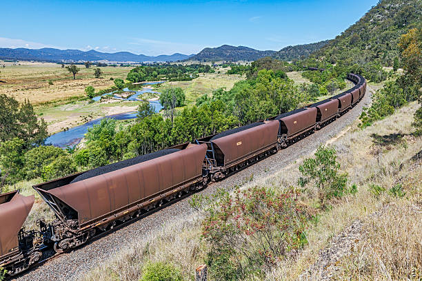 istock Loaded Black Thermal Coal Train in Beautiful River Valley Environment 2248519275