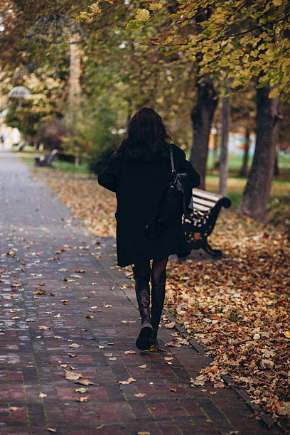 istock A woman walks through an autumn park. 2248525593