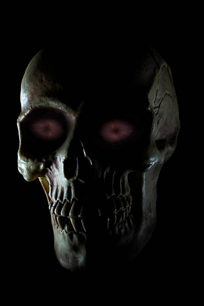 Purple eyes glowing on a human skull on a black background