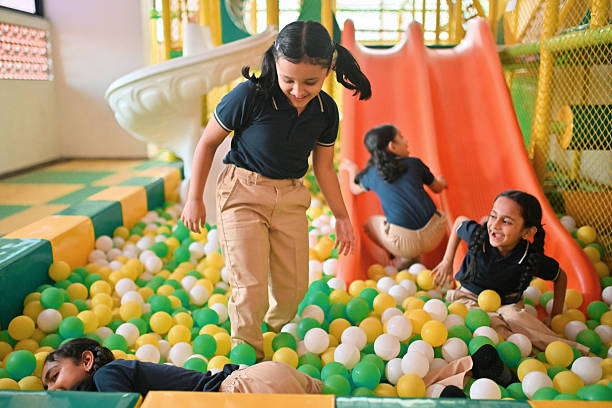 Happy playful kids enjoying while playing the the pool of balls.