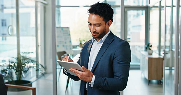 istock Business, man and writing on tablet in office for funding request review, reading application or sign. Financial analyst, tech and stylus at work for investment deal, digital signature and agreement 2248530367