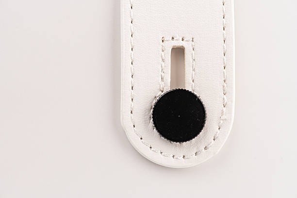 Close-up of a mini leather guitar amp speaker, featuring a patterned belt with contrasting circular design and visible stitching Light, clean aesthetic, profile perspective, shallow depth of field,