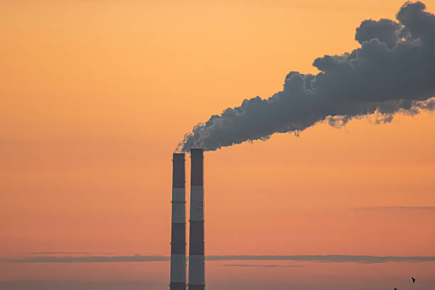 istock A sunset scene featuring several tall, cylindrical chimneys with multiple flues against an orange and cool sky backdrop The setting emphasizes vertical lines and creates a sense of perspective 2248530757