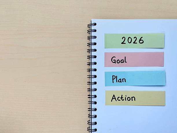 istock New year 2026 resolution concept. Goal, plan and action written on colorful sticky note on notebook with wooden table background 2248534210