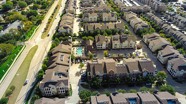 istock Dense units in mega apartment complex suburbs Dallas Fort Worth, structured layout with brown roofs, parking lots, driveways, community pool, courtyard, indicating managed residential community 2248535436
