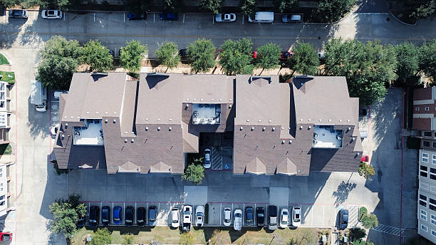 istock Tree lined walking paths in modern apartment building complex, lush landscaping. Brown-roofed with industrial HVAC unit packages, dense outdoor parking lot with handicap mark, Flower Mound, Texas 2248535454