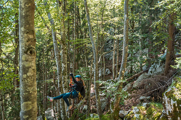 istock Young Female Adventurer Gliding Through The Lush Forest Canopy 2248536483