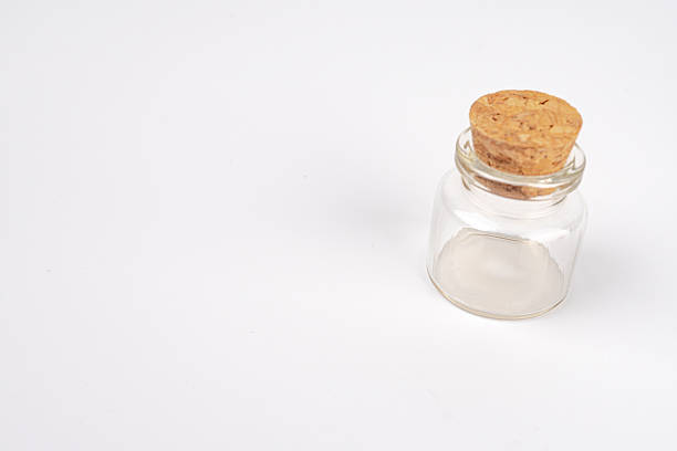 istock A white background with a sealed, opaque glass jar, possibly containing potions or alchemy substances, accompanied by an indistinct circular object on the lid Minimalistic style with clean lines and 2248539291