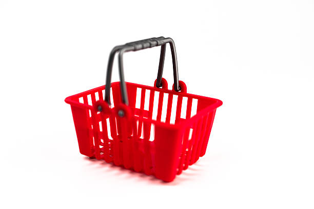 istock A pair of red shopping baskets, connected by a black handle, positioned side by side on a light gray surface against a dark background 2248539630
