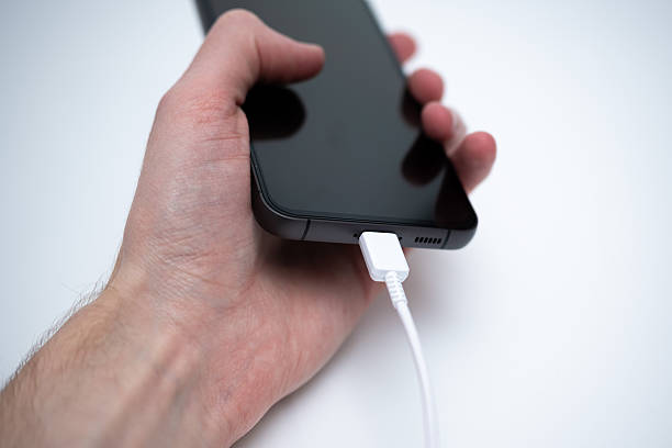 istock Charging smartphone with cable in hand close-up for digital technology concept 2248540601