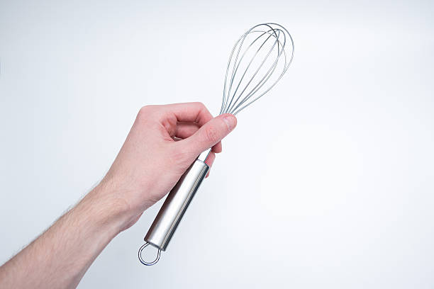 istock Hand Holding Metal Whisk on Light Background 2248540775