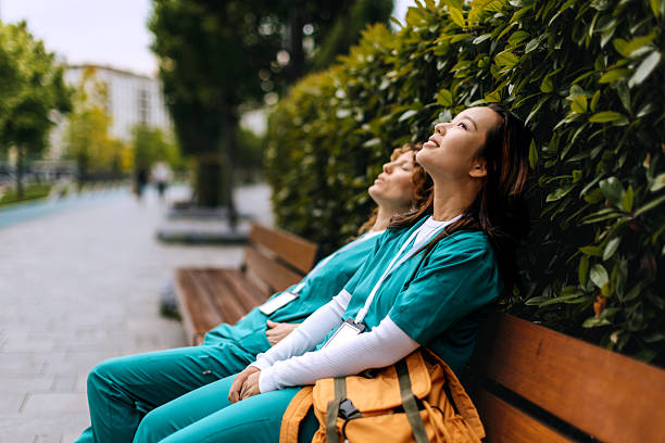 istock Two female nurses relaxing on a bench outdoors 2248542874