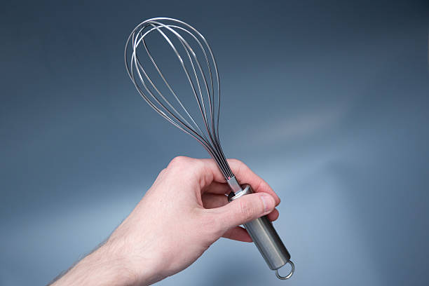istock Hand Holding Metal Whisk on Light Background 2248542885
